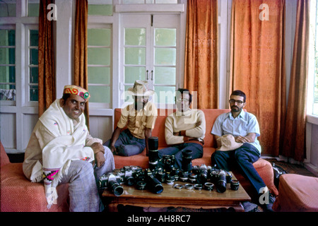AAD71612 Four photographer friends with camera equipment on holiday resting in hotel room Stock Photo
