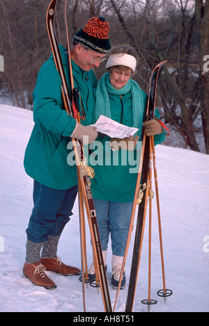 Couple age 58 with map and cross country skis at Plymouth Park Reserve. Minneapolis Minnesota USA Stock Photo