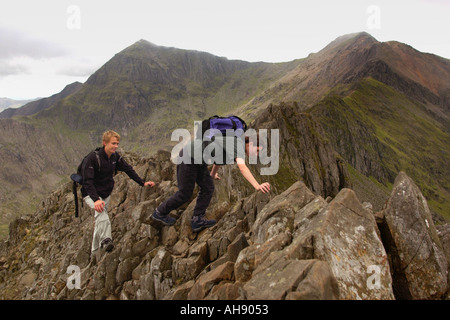 Walkers crossing the Crib Goch ridge on route to summit of Mount Snowdon, top left, Gwynedd North Wales UK Stock Photo