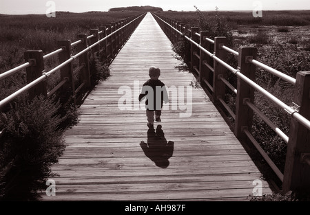 Small boy walking on pathway into future Life Stock Photo