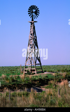 A wooden windmill pumps water for cattle on the high plains of New Mexico Stock Photo