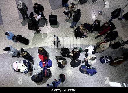 A group of  passengers wait in line to check-in inside a terminal at Logan International Airport in Boston Massachusetts Stock Photo