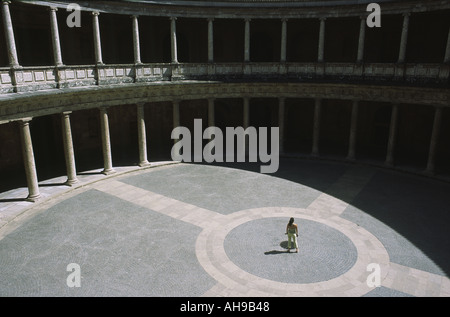 Looking down to a Spanish woman standing in the center of the courtyard of the Palace of king Carlos V in Alhambra in Granada, southern Spain. Stock Photo