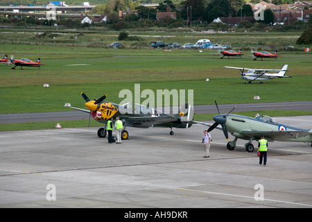 Warbird enthusiasts with cameras by Kittyhawke and North American P-51 Mustang on static display at Shoreham Airshow, Shoreham Airport, Sussex Stock Photo