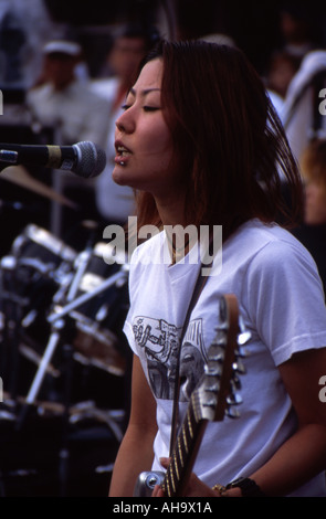 Okinawan girl sings and plays rock music in Okinawa City Stock Photo