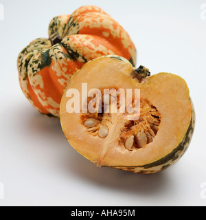 A whole and a half harlequin squash on a white background editorial food Stock Photo