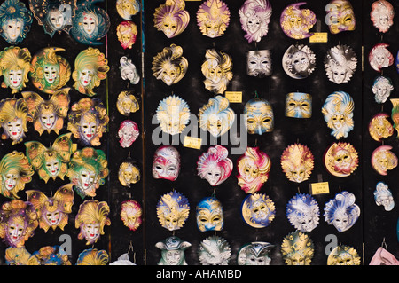 Color horizontal image of an array of Venician masks on a black background in Venice Italy Stock Photo