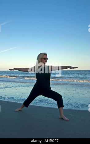 Young Woman Practices Yoga Exercises At Hunting Island SC USA Stock Photo