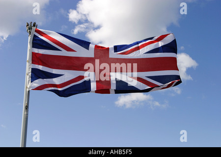 Union Jack flying from left to right against blue sky and some white cloud on a warm summer day. Edinburgh, Scotland Stock Photo