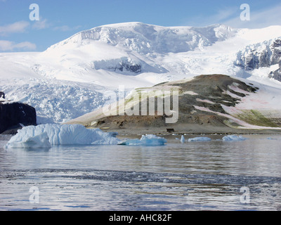 Mountains a glacier and icebergs surround the old British research base named Danco Hut Base O on Danco Island Antarctica Stock Photo