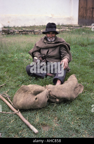 Portrait of an old man in the town of Villa de Leyva near Bogota Colombia Near him on the ground is a cane and burlap sack Stock Photo