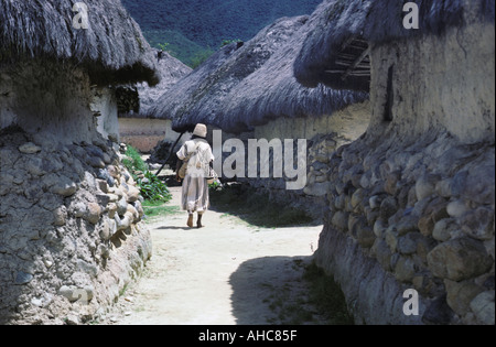 A native Arhuaco indian man walks through the village of San Sebastian in the Sierra Nevada de Santa Marta mountains of Colombia Stock Photo