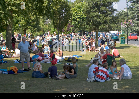 Crowds of tourists relaxing by River Windrush Bourton on the Water Cotswolds UK Stock Photo