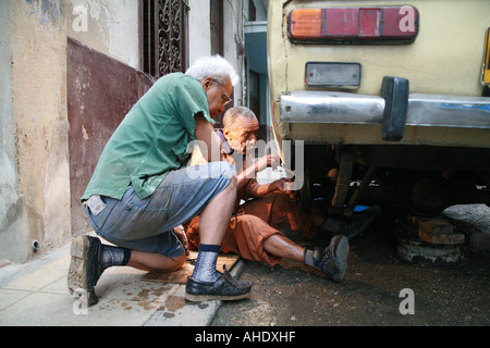 La Habana Cuba two seniors working on a lada Stock Photo