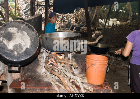 A young boy looks at the camera while food cooks over an open fire at El Ciruelo. Stock Photo