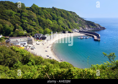 The beach and sheltered harbour at Polkerris, near Fowey, Cornwall, with people sunbathing on the beach in summer. Stock Photo