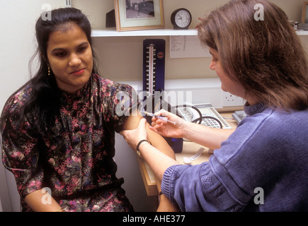 Female patient having injection from doctor. Stock Photo