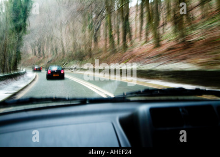Cars ahead driving through sleet and snow photographed through the windscreen Stock Photo
