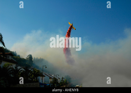 An Air Tractor AT-802 Fire-fighting aircraft drops flame retardant over houses in Kiryat Shemona following a rocket missile attack by Hezbollah Stock Photo