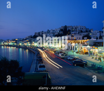 An evening view of the bustling harbour of Naxos Town at dusk with cars and cafés on quayside Naxos Island Greek Islands Stock Photo