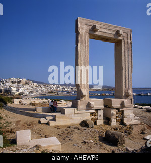 Square arched Temple of Apollo with couple at base and Naxos town and bay beyond Naxos Island Greek Islands Greece Stock Photo