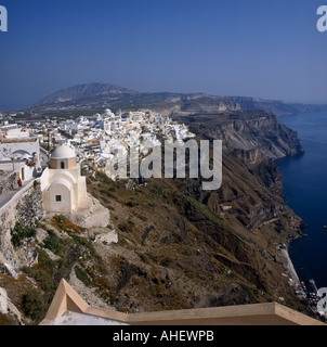 Cliff top view of clustered white-washed houses and church of Fira and sea below on Santorini The Greek Islands Greece Stock Photo