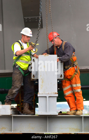 Working on the directional guides and jacking points of a road bridge being winched over the River Usk at Newport South Wales UK Stock Photo
