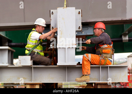 Working on the directional guides and jacking points of a road bridge being winched over the River Usk at Newport South Wales UK Stock Photo