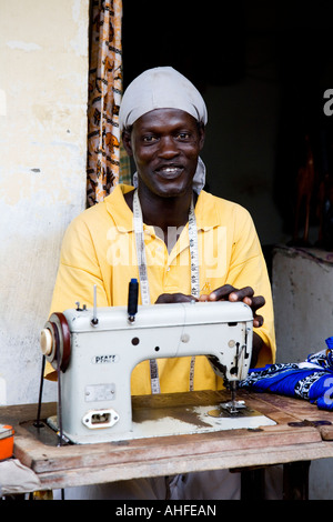 Protrait of a smiling tailor at work on his stall in the Senegambia Craft Market, Kololi, The Gambia, Africa Stock Photo