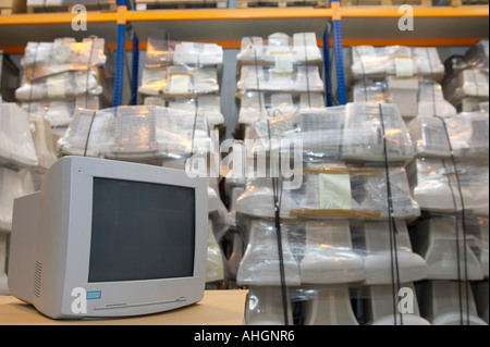 refurbished computer CRT monitor in warehouse containing pallets of old discarded computers for recycling Stock Photo