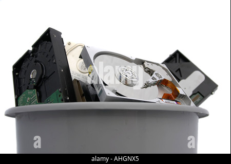 Pile of old broken open hard discs in a grey bin against a white background Stock Photo