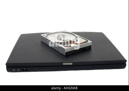 Laptop and open broken hard disc against a white background Stock Photo