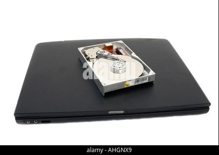 Laptop and open broken hard disc against a white background Stock Photo