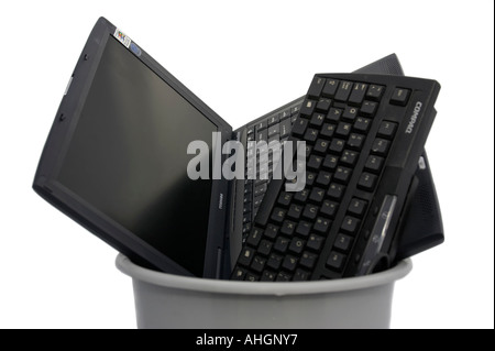 laptop and keyboard piled into plastic grey bin against a white background Stock Photo
