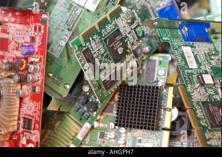 various computer component internal circuit boards including video card in a pile waiting to be recycled