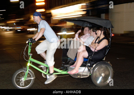 Passengers on rickshaw bicycle ride in Soho, London England UK Stock Photo