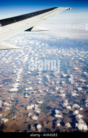 View from aeroplane window of puffy clouds and bright blue sky with ...
