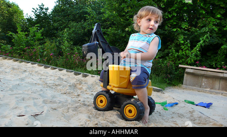 small boy with toy digger in sandbox Stock Photo
