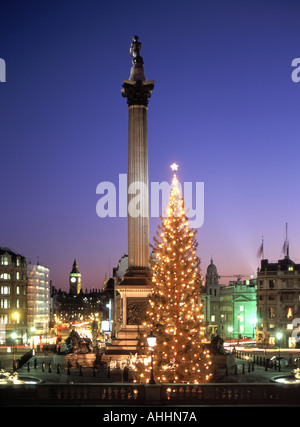 Dusk sky Trafalgar Square scene with lights & decorations on Christmas tree Nelsons column Big Ben distant end of Whitehall iconic London England UK Stock Photo