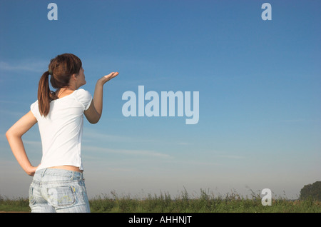 Young woman outdoors blowing on hand Stock Photo