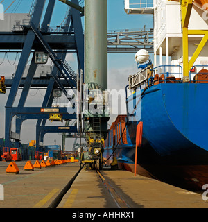 shipping and logistics container cranes with docked container ship Stock Photo