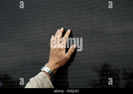 Veteran touching hand over the names of war dead at the Vietnam Veterans Memorial, Washington DC, USA Stock Photo