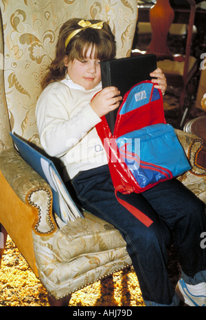Back to school. Girl sitting on a stack of books Stock Photo - Alamy