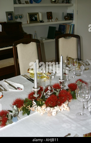 dining room table set for Christmas Dinner with Pohutukawa flower arrangement festive setting in a private home New Zealand Stock Photo