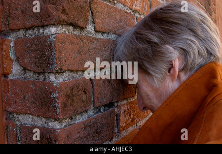 lonely woman by brick wall Stock Photo