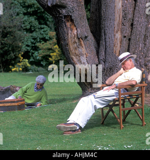 ELDERLY MAN ASLEEP AFTER A PICNIC IN A PARK Stock Photo