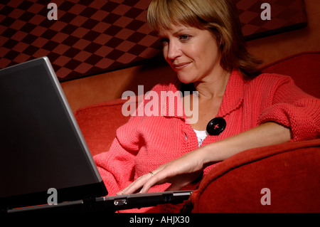 Woman on a sofa using a laptop Stock Photo