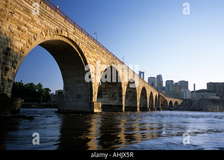 JAMES J. HILL STONE ARCH BRIDGE OVER THE MISSISSIPPI RIVER. SKYLINE OF MINNEAPOLIS, MINNESOTA IN BACKGROUND. SUMMER.  U.S.A. Stock Photo