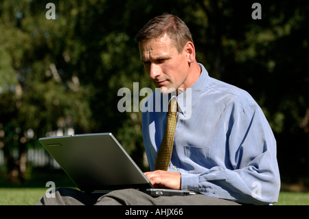 Businessman outdoors using a laptop Stock Photo