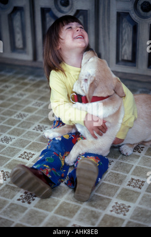 Dog licking Little Girl's Neck and Chin Stock Photo